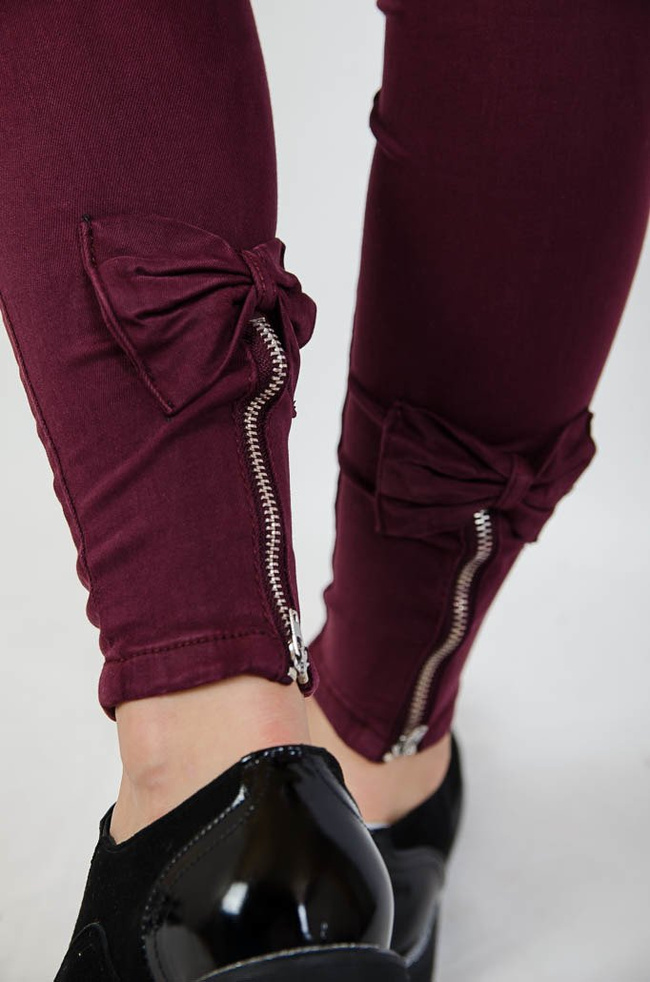 Bordowe spodnie jeansowe z zamkiem na nogawce oraz kokardą