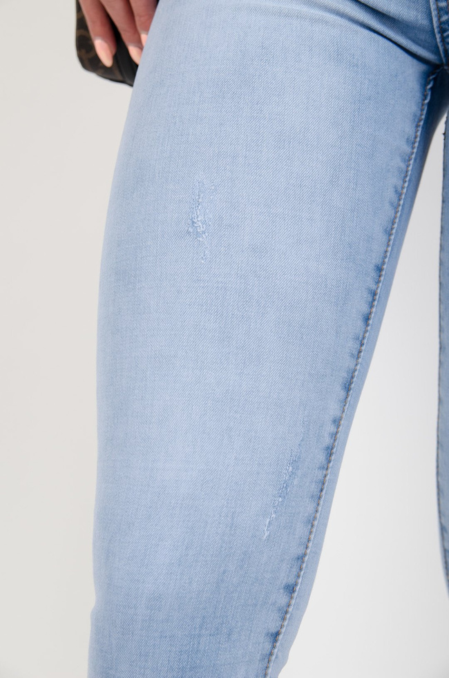 Jasne spodnie jeansowe push up z delikatnymi przetarciami