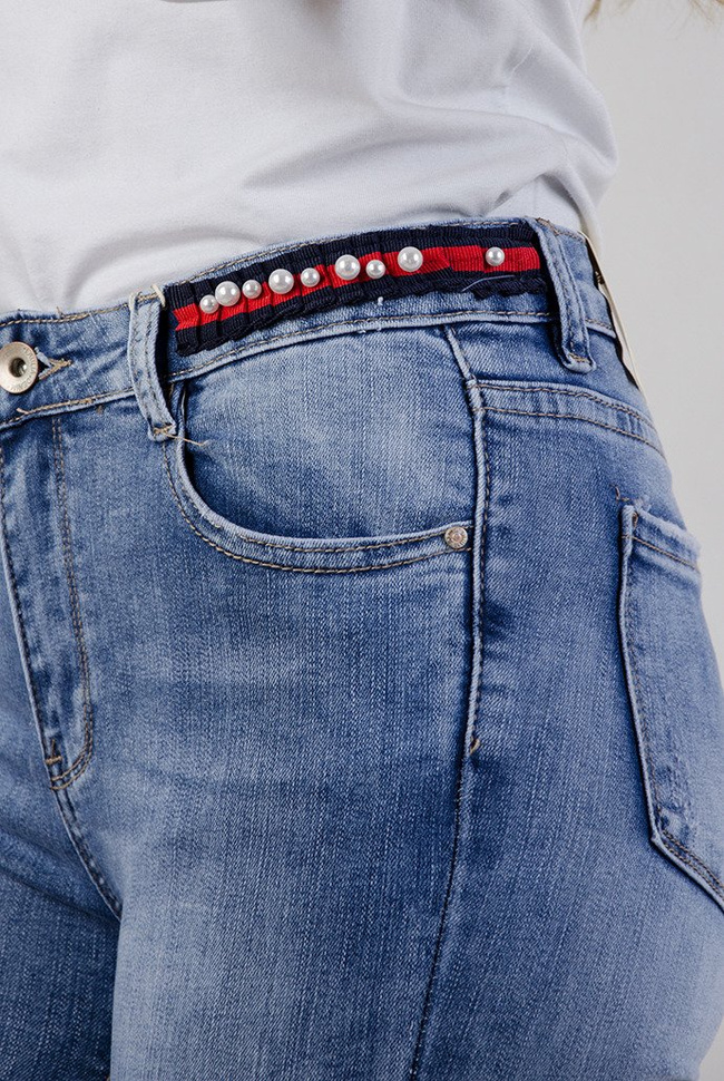 Spodnie jeansowe z ozdobami oraz wywinięta nogawką
