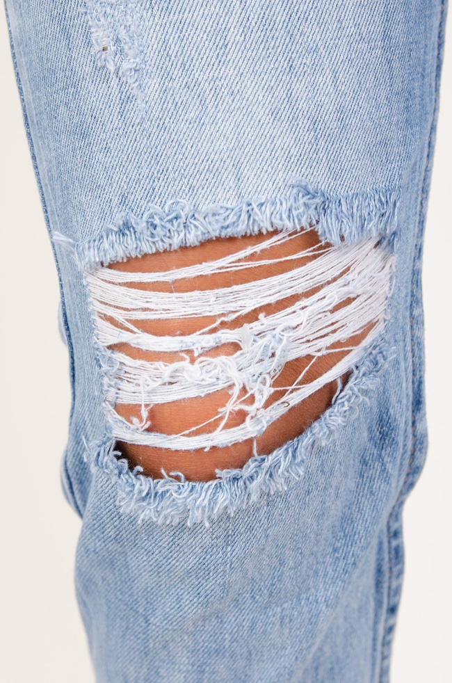 Jeansowe boyfriendy z dziurami i drobnym napisem pod kieszenią