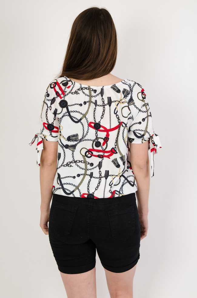 Biała bluzka z gumą na dole i wzorem pasków oraz łańcuszków