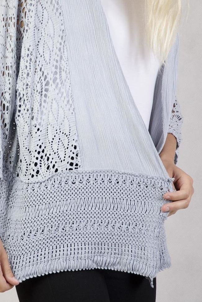 Koronkowa narzutka z szerokim plecionym pasem na dole szara