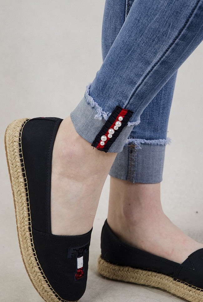 Spodnie jeansowe z ozdobami oraz wywinięta nogawką