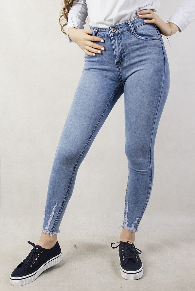 Jasne spodnie jeansowe z szarpaniem przy nogawce