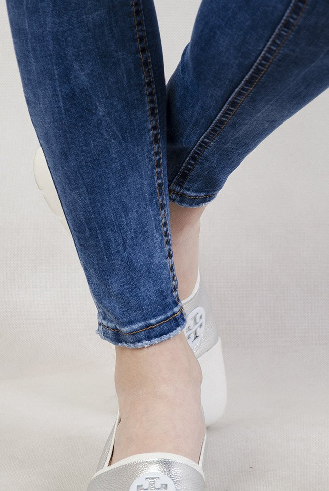 Jasne spodnie jeansowe z przetarciami oraz wysokim stanem