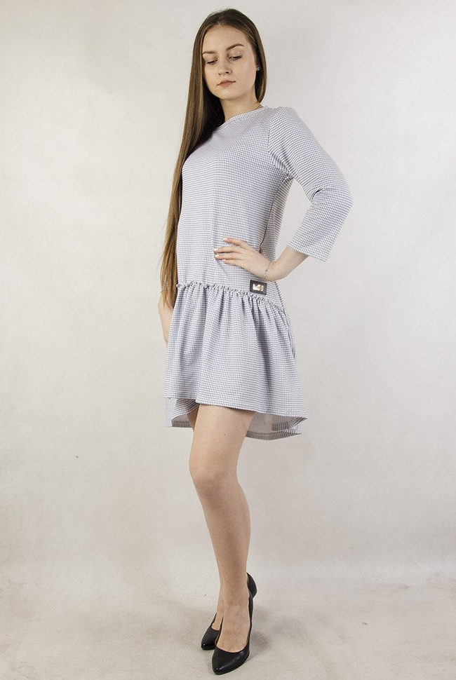 Biała sukienka w szare wzory  z naszywką i falbaną na dole