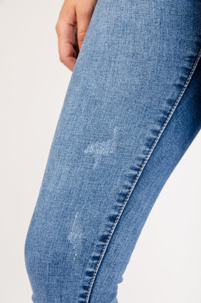 Jasne spodnie jeansowe z przetarciami