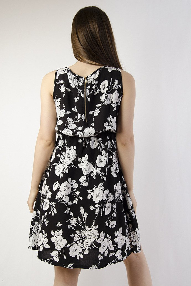 Czarna sukienka w białe kwiaty z zamkiem z tyłu, zakończonym perłą.