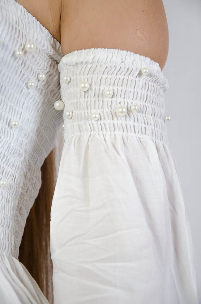 Biała bluzka z odkrytymi ramionami oraz perełkami