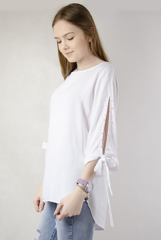 Biała asymetryczna bluzka z wiązaniem przy rękawie oraz perełkami