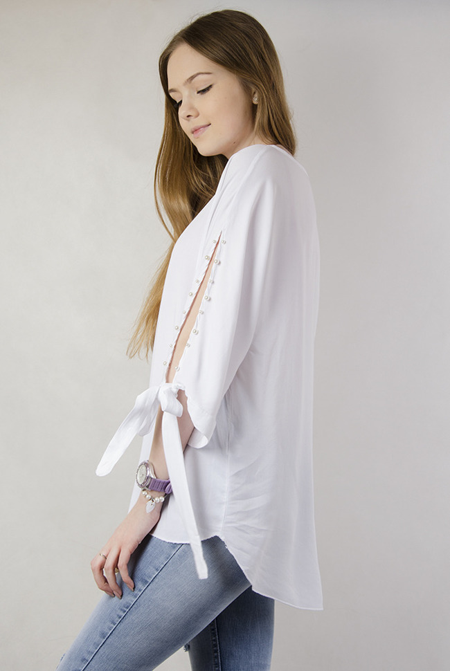 Biała asymetryczna bluzka z wiązaniem przy rękawie oraz perełkami