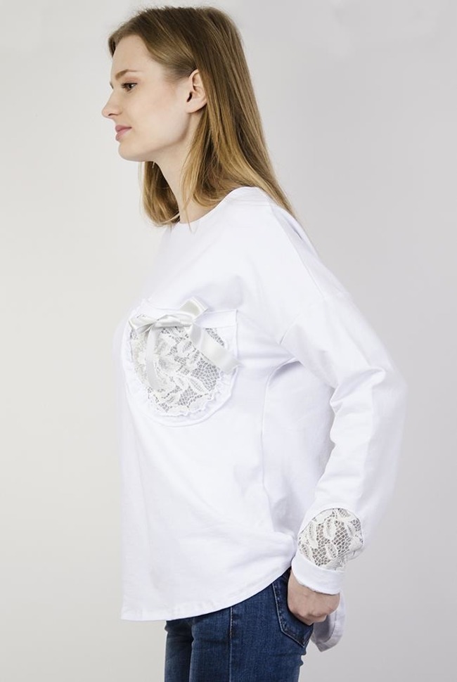 Biała bluzka z kokardką przy kieszonce i zdobieniami przy rękawach