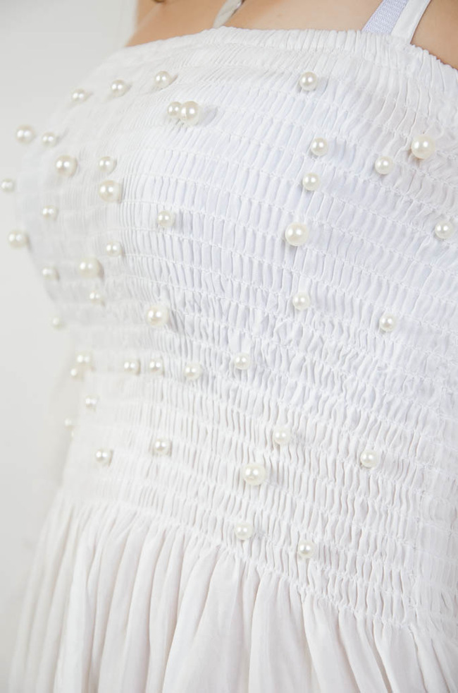 Biała bluzka z odkrytymi ramionami oraz perełkami