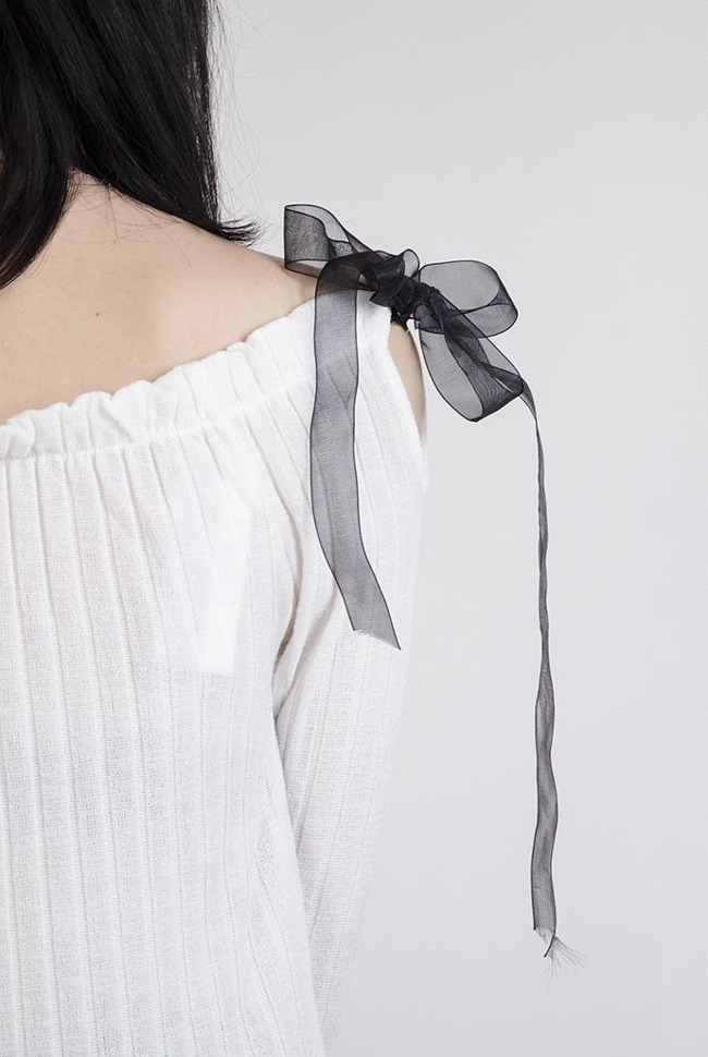 Biała prążkowana bluzka z odkrytymi ramionami wiązana czarną wstążką