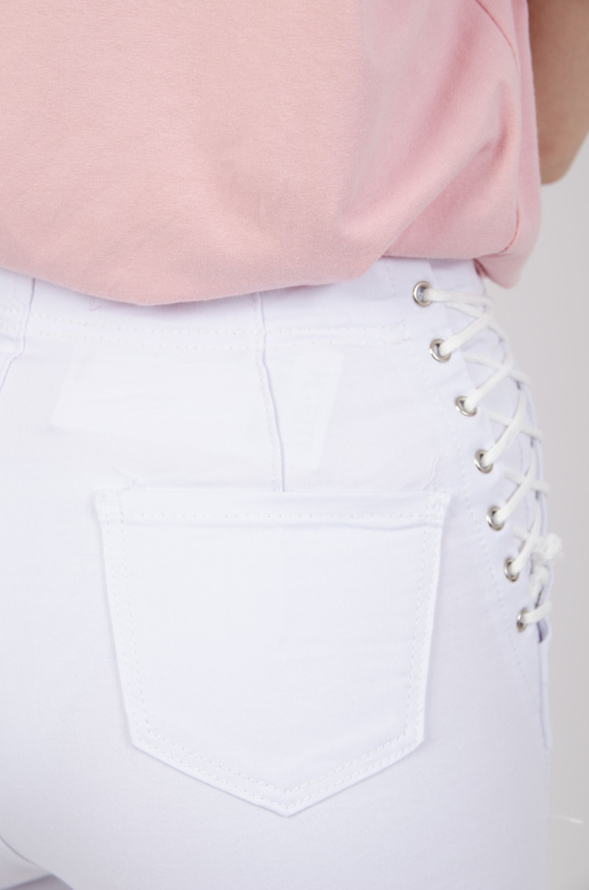 Białe  jeansowe spodnie modelujące z wiązaniem na boku