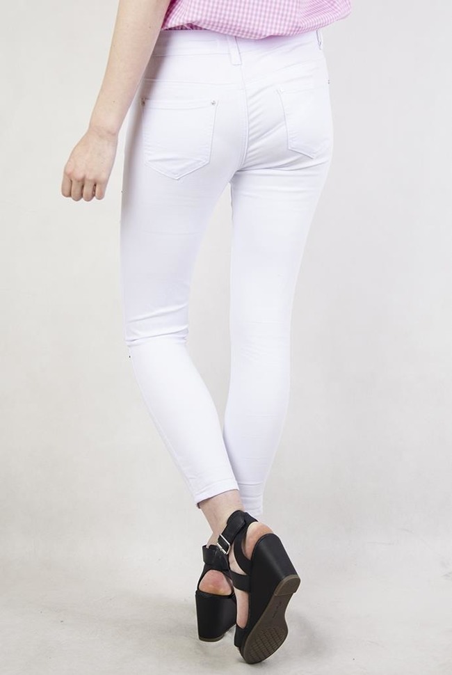 Białe spodnie jeansowe z naszywkami i dziurami