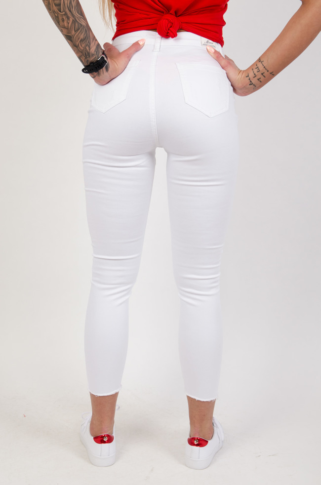 Białe spodnie jeansowe z przetarciami zapinane na guziki