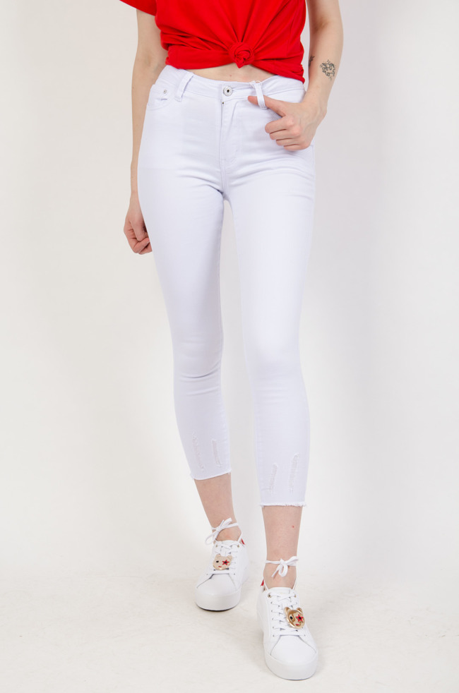 Białe spodnie jeansowe z szarpaniem na dole nogawki