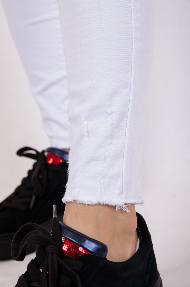 Białe spodnie jeansowe z wysokim stanem oraz szarpaniem na nogawce