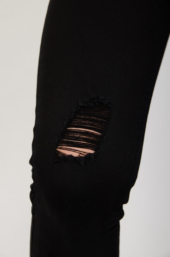 Czarne spodnie jeansowe z przetarciami zapinane na guziki