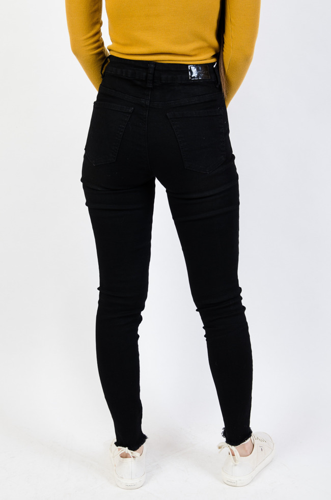 Czarne spodnie jeansowe z szarpanymi nogawkami 