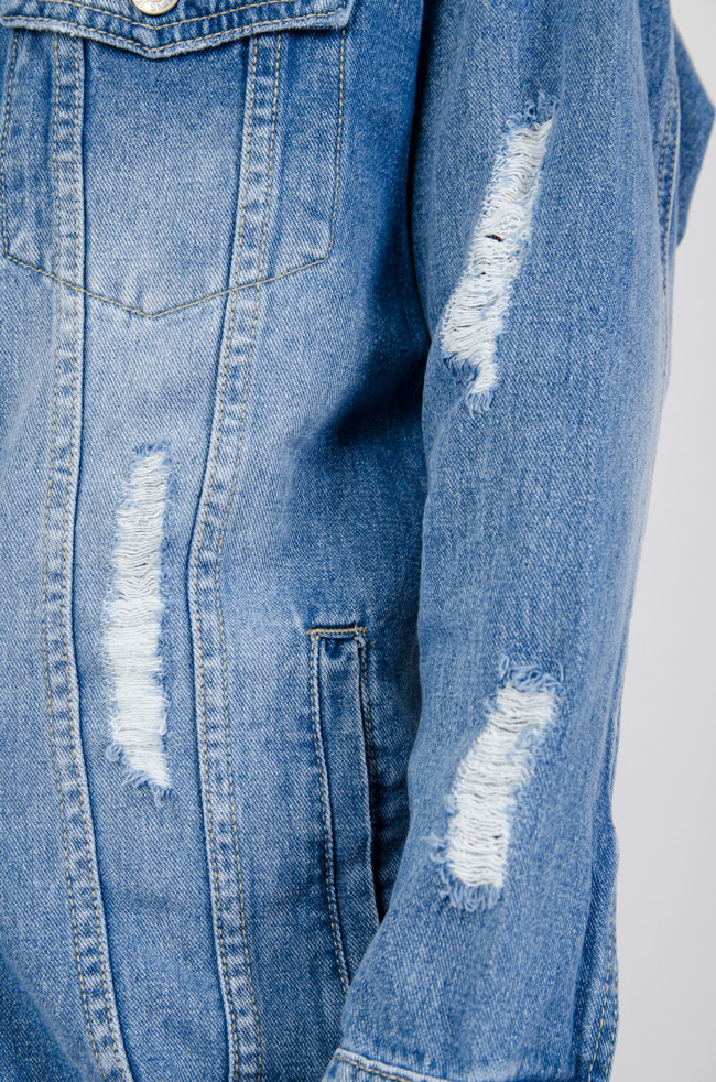 Długa kurtka jeansowa z przetarciami oraz szarpaniem na dole