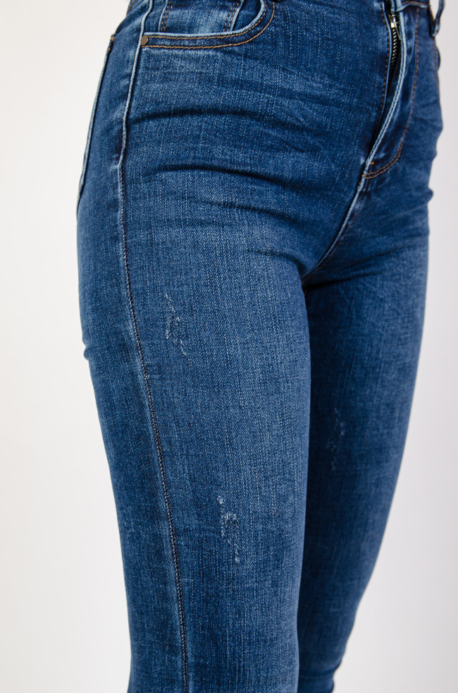 Dopasowane spodnie jeansowe z szarpaniem na dole nogawki