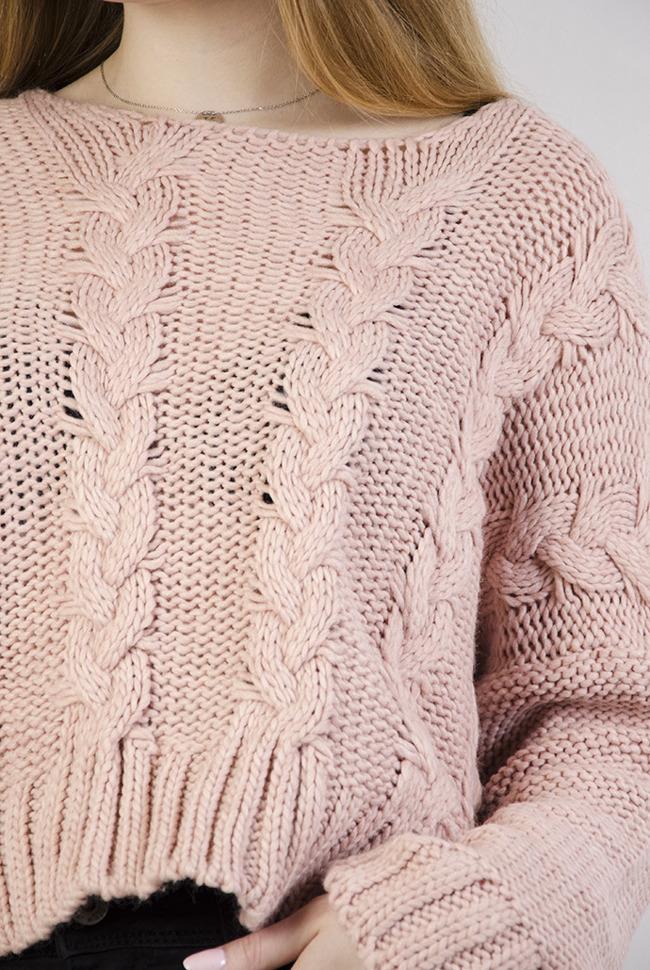 Krótki różowy sweter z przeplatanymi warkoczami.