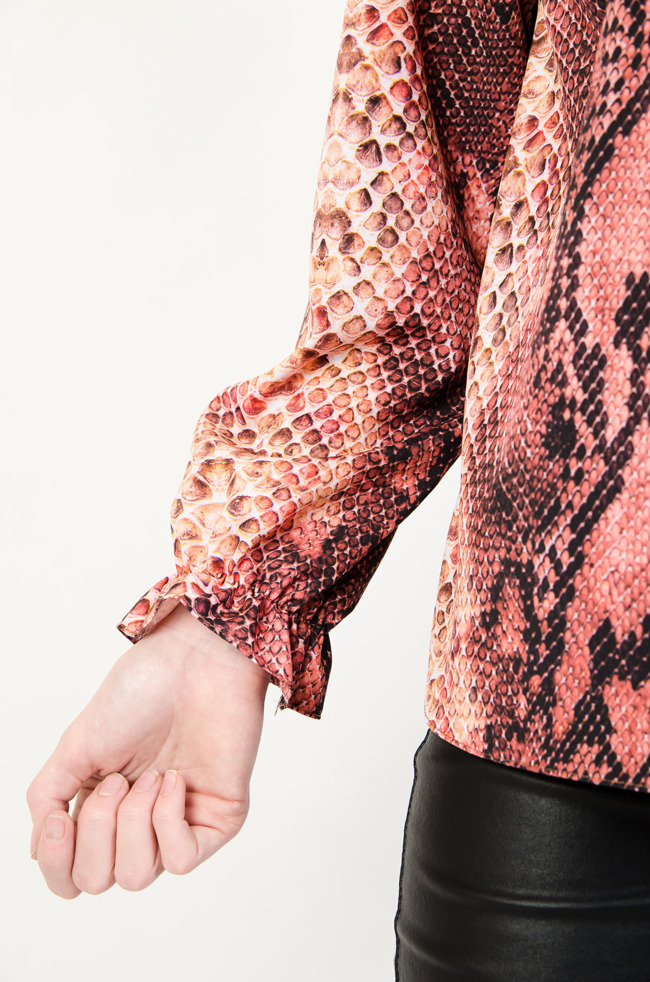 Różowa bluzka z wężowym wzorem z falbanką przy rękawie