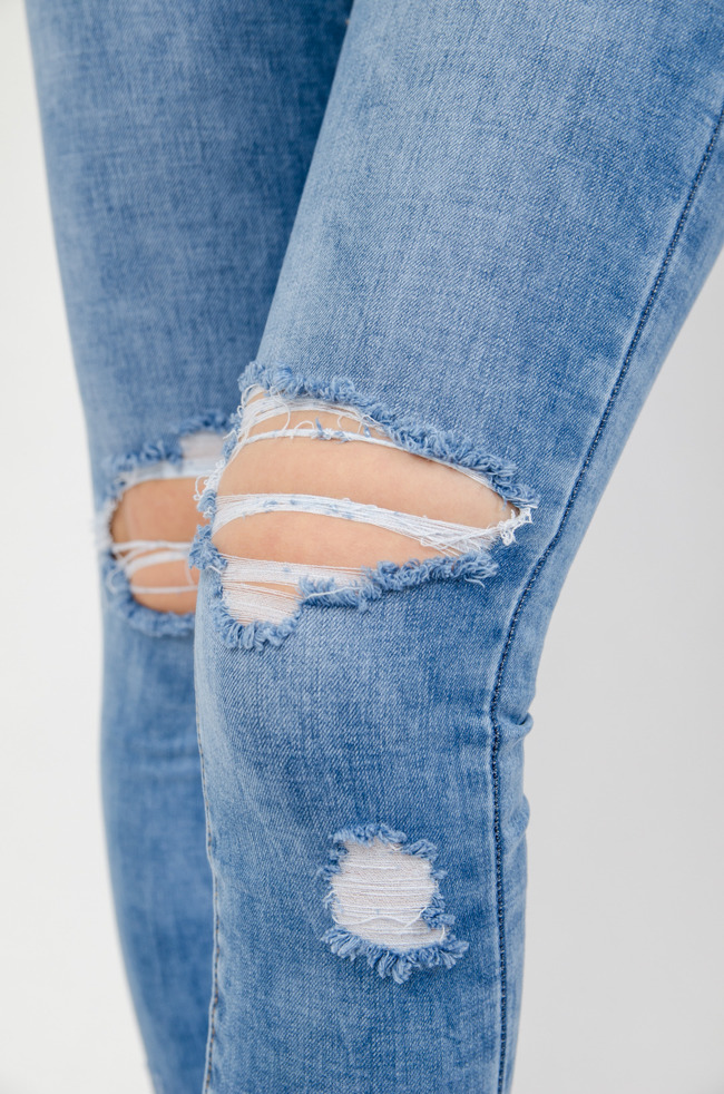 Spodnie jeansowe z przetarciami oraz przecięciami na kolanach 