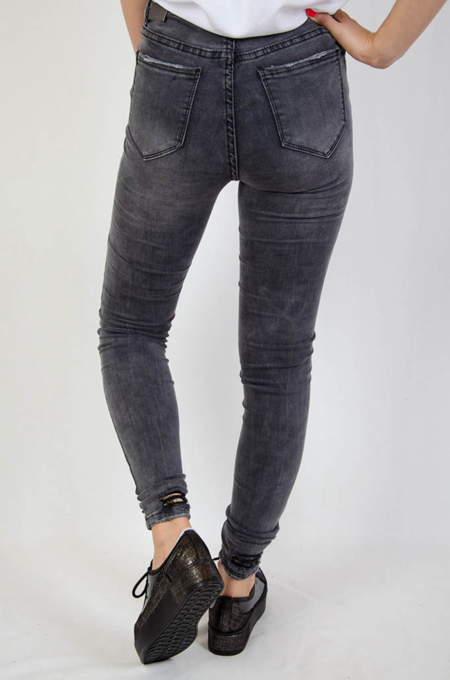 Szare spodnie jeansowe z szarpaniem na nogawce
